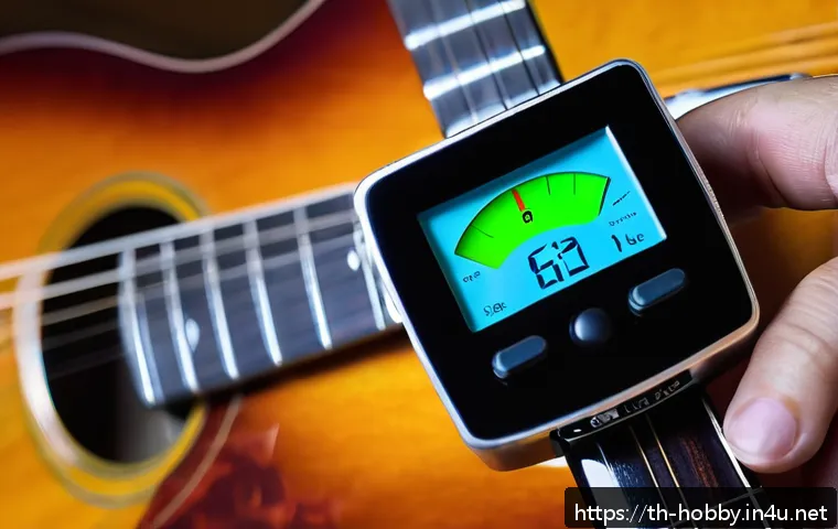 튜닝 악기 - A detailed close-up image of a musician&rsquo;s hand adjusting a digital clip-on guitar tuner attached to ...
